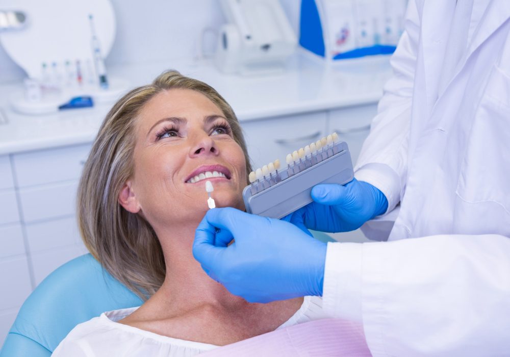 doctor-holding-tooth-whitening-equipment-by-patient.jpg